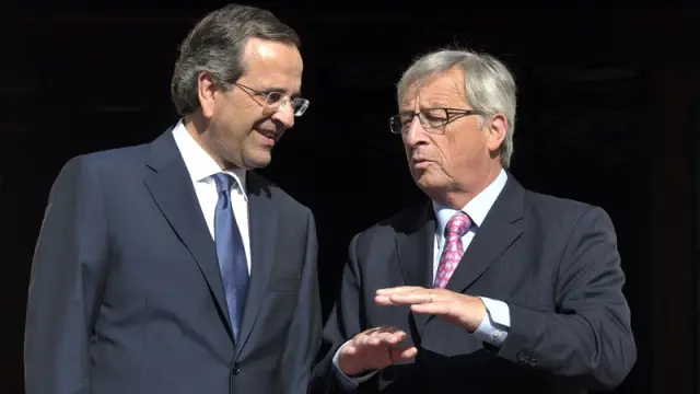 El primer ministro griego, Antonis Samaras, habla con Juncker, director del Eurogrupo