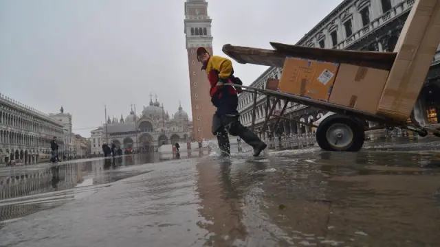 Un hombre empuja sus pertenencias por las calles inundadas de Venecia