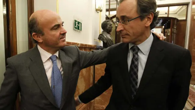 El ministro de Economía, Luis de Guindos, conversa con el portavoz parlamentario del PP, Alfonso Alonso