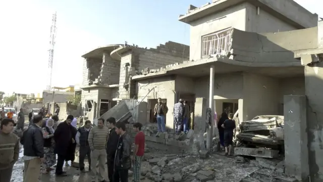 Un grupo de iraquíes inspeccionan el escenario de un ataque con coche bomba en Kirkuk