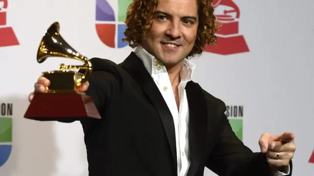 El cantante español David Bisbal sostiene su premio a Mejor Trabajo Vocal Tradicional de Pop.