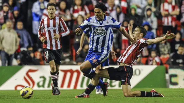 El delatentero del Athletic, Óscar de Marcos (d) lucha un balón con el centrocampista del DeporAbel Aguilar (c), durante el partido en San Mamés