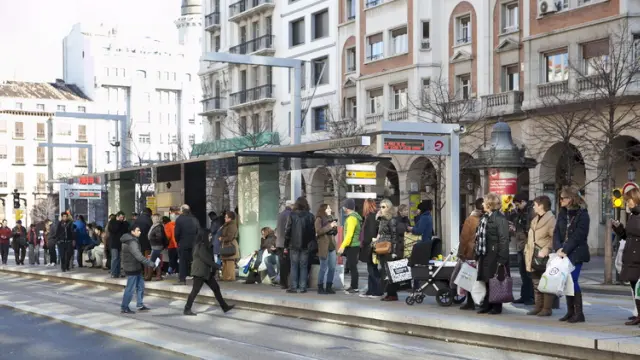 Decenas de personas esperan el tranvía en la parada de la plaza de Aragón, ayer por la mañana.