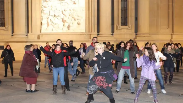 Activistas contra la violencia de género bailan en la plaza del Pilar