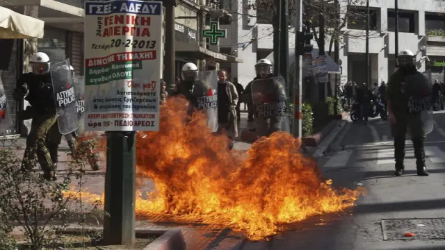 Agentes de policía antidisturbios, tras el lanzamiento de un cóctel molotov durante una manifestación frente al Parlamento griego