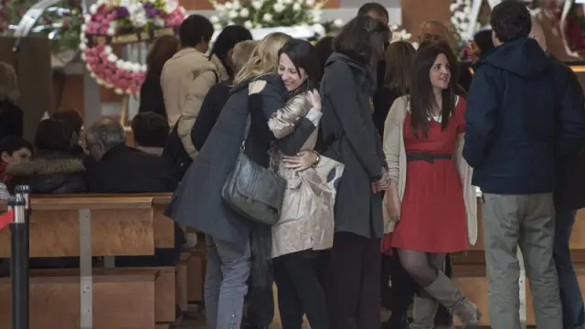 Elvira, hija de la fallecida Mariví Bilbao, abraza a una amiga durante el funeral.