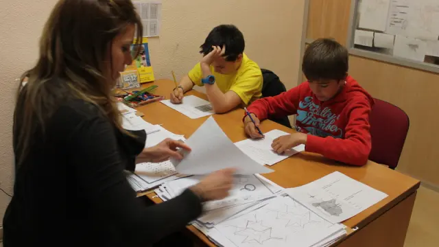 Madelín, pedagoga de AATEDA en Zaragoza, trabajando con Manuel y Miguel.