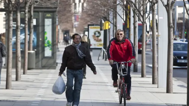 Un peatón y un ciclista caminan por el paseo Independencia