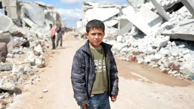 Un niño sirio, en una calle llena de escombros tras los bombardeos