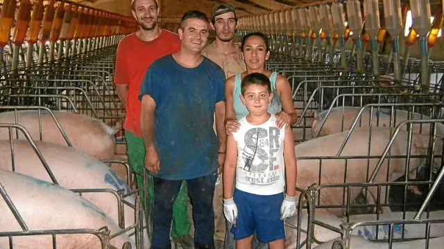 Pedro Sancho, su mujer y su hijo, con dos empleados ?detrás? de su granja en Fuentespalda