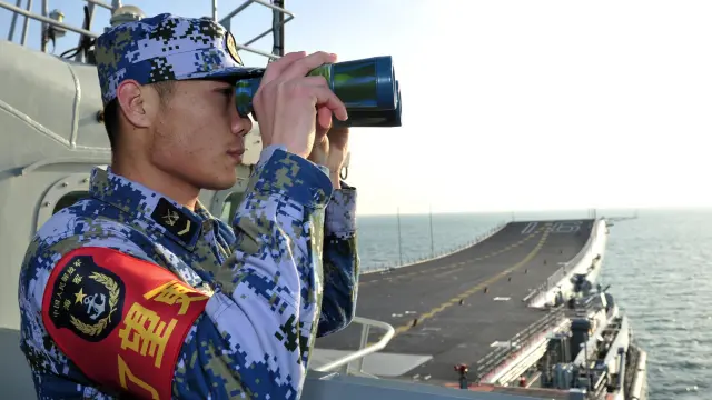 Soldado chino vigila desde un portaaviones
