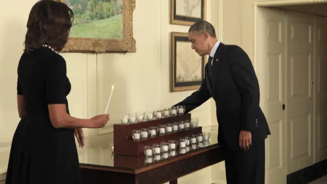 Barack y Michelle Obama encendiendo velas en memoria de los fallecidos