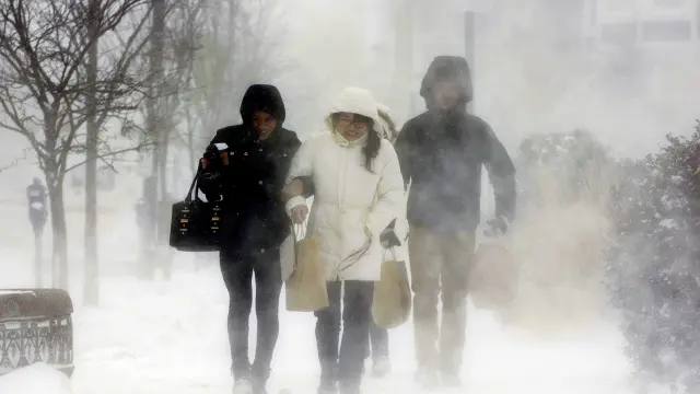 Tres personas caminan entre la nieve en el estado de Nueva York