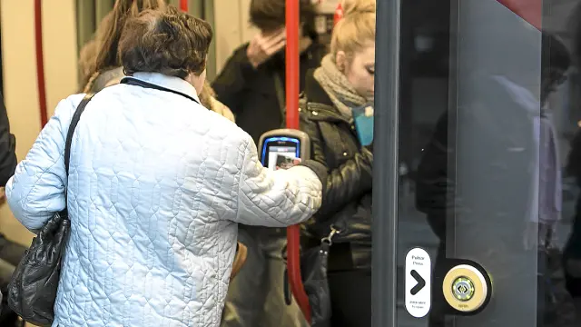 Una susuario del tranvía valida correctamente con su tarjeta bus.
