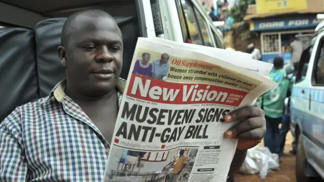 Un hombre lee un periódico que trata la 'ley anti-gay' ugandesa