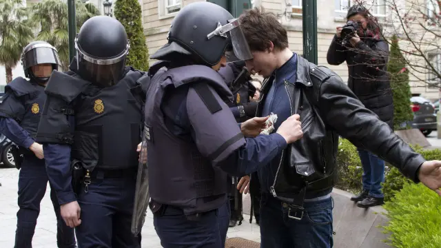 Varios policías registran a un joven durante la manifestación contra la LOMCE