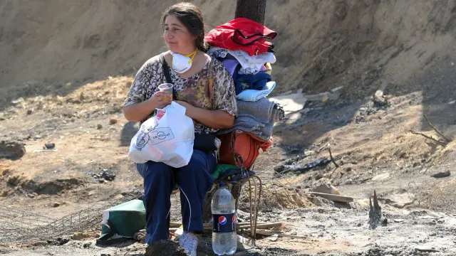 Una mujer espera ayuda con sus pertenencias en Valparaíso