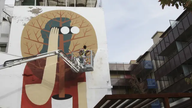 Un artista urbano pinta la pared de un edificio