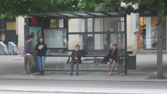 Varias personas esperan en una parada de bus durante uno de los paros