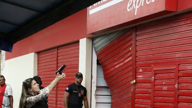 Una policía civil junto a una tienda saqueada