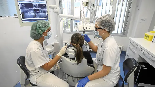 Cristina Artiles ?izquierda? e Inés Casado atienden a una paciente en la clínica universitaria de Huesca.
