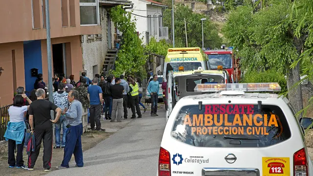 Los servicios de emergencia y vecinos de Nuévalos, junto a la vivienda incendiada -la de las parras-.