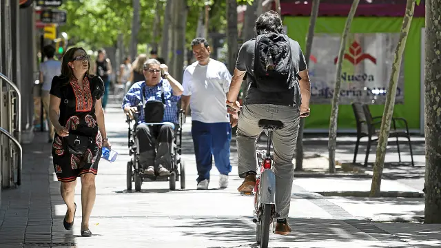 Un usuario del servicio Bizi circulando ayer por la acera del paseo de Pamplona: la ordenanza lo permite pero la ley de Tráfico no.