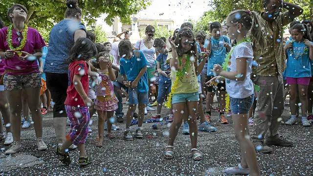 Varios niños, concentrados frente alAyuntamiento de Quinto durante la lluvia de confeti.