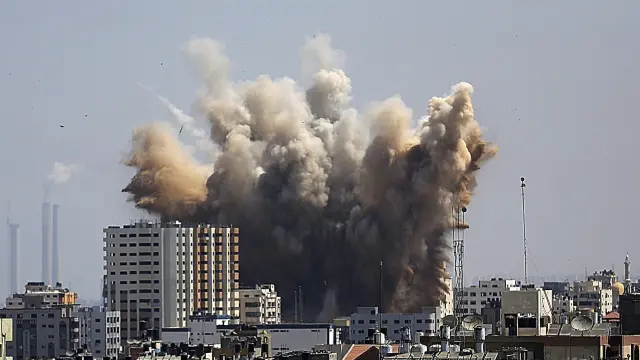 Una columna de humo se eleva sobre un edificio atacado por fuerzas israelíes este viernes