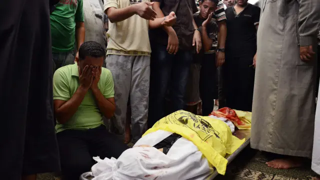 Un hombre palestino reza ante el cuerpo de un joven de 17 años muerto en un ataque israelí