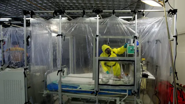 Personal militar con trajes especiales mientras trabajan en la simulación de un caso de enfermo de un virus contagioso.