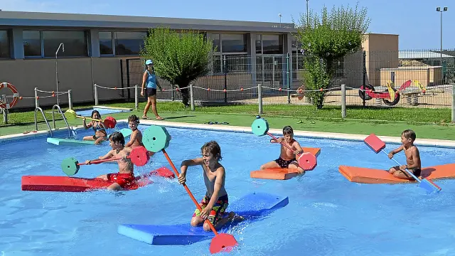 Los niños disputaron una carrera de piraguas en la piscina municipal.