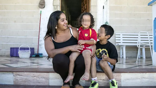 El pequeño Joel, junto a su madre, María José Dos Angos, y su hermano Kevin, ayer, a las puertas de su casa en Montañana.