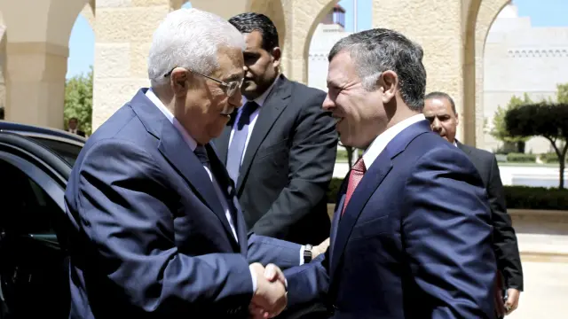 El presidente palestino, Mahmud Abás (izda), saluda al rey Abdulá II de Jordania