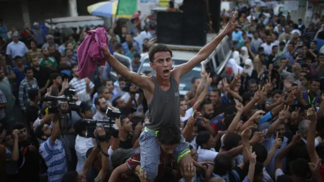 Miles de gazatíes se echaron a las destruidas calle de Gaza para celebrar, con disparos al aire.