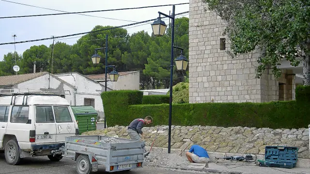 Dos empleados trabajan en el sistema de alumbrado del barrio de Santa Engracia.