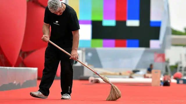 Un empleado limpia la alfombra roja antes de la inauguración de la 71 edición del festival.