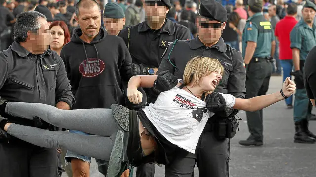 Agentes de la Guardia Civil se llevan a una de las manifestantes.