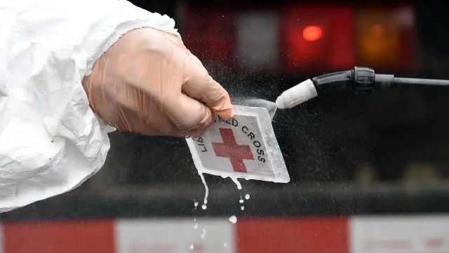 Personal sanitario de Cruz Roja desinfecta su tarjeta de identificación en Liberia.