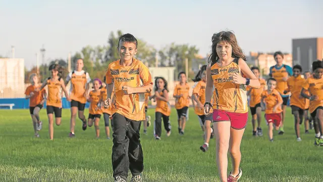 El pequeño Jhon, acompañado de su prima Laura, volvió a correr ayer por el césped del Centro Aragonés del Deporte.