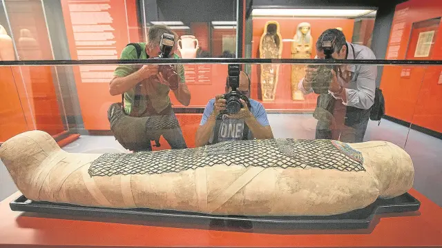 Tres fotógrafos, ante la momia de Pauiamen, hallada en Tebas, y datada entre los años 712 y 525 antes de Cristo.