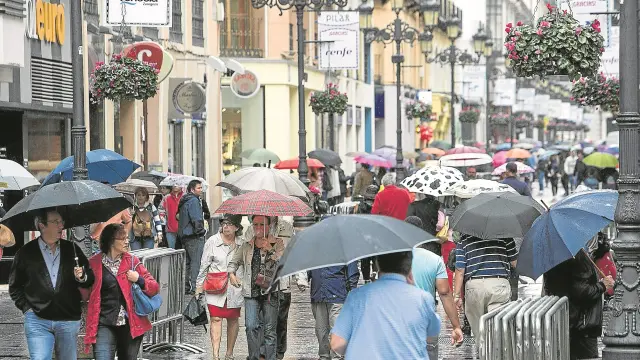 La calle de Alfonso I era un mar de paraguas ayer a mediodía. Pese a la lluvia, cientos de personas se acercaron al centro a disfrutar del ambiente.