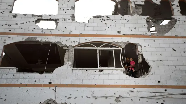 Un padre y su hijo en un edificio devastado en Gaza