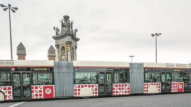 Uno de los autobuses biarticulados que circulan por Barcelona, a su paso por la plaza de España.