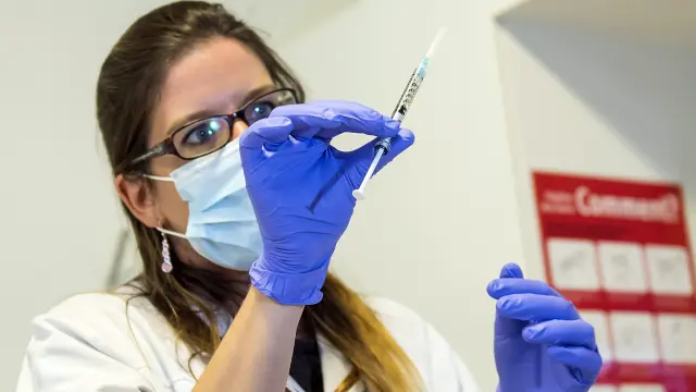 Una enfermera sostiene una dosis de la vacuna experimental contra el ébola antes de inyectásela a un voluntario de una ONG