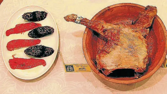 Plato de morcilla con pimientos y lechazo asado.