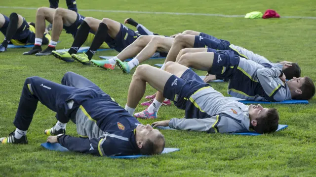 Los futbolistas del Real Zaragoza realizan estiramientos al término de un entrenamiento.
