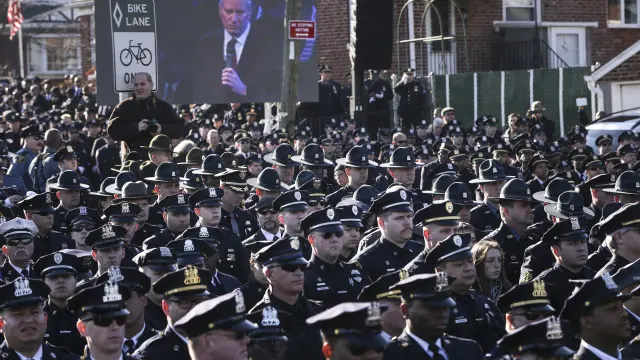 Los policías escuchan de espaldas a un vídeo el discurso de De Blasio