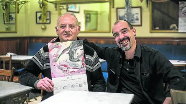 El artista Paco Rallo y el propietario Óscar Blázquez posan con el calendario del Café de Levante.