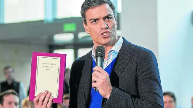 Pedro Sánchez sostiene un ejemplar de la Constitución durante su discurso en Logroño.